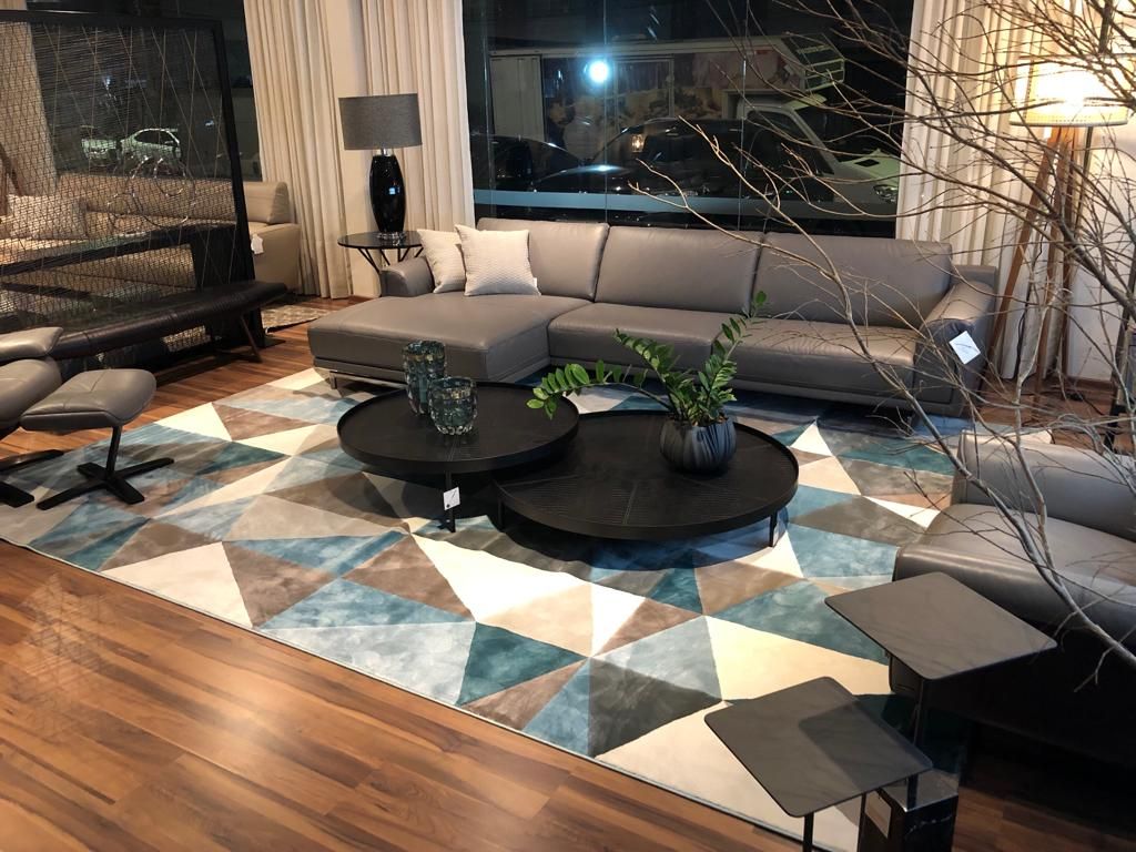 Diamond-patterned rug in teal and cream grounding a family room