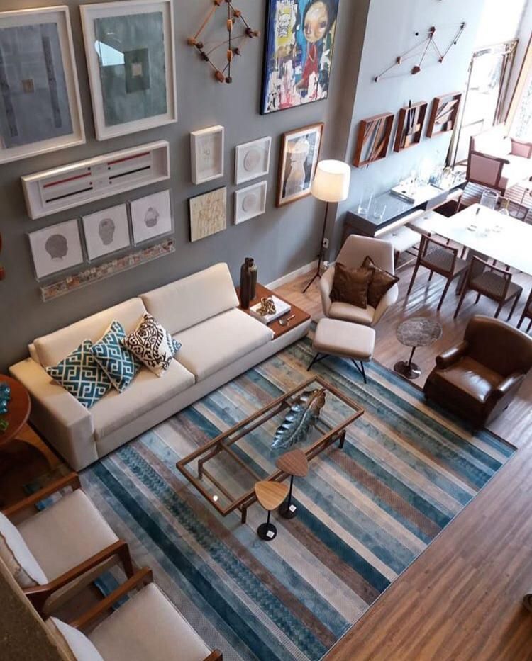 Living room where a framed gallery wall sits above a teal striped rug