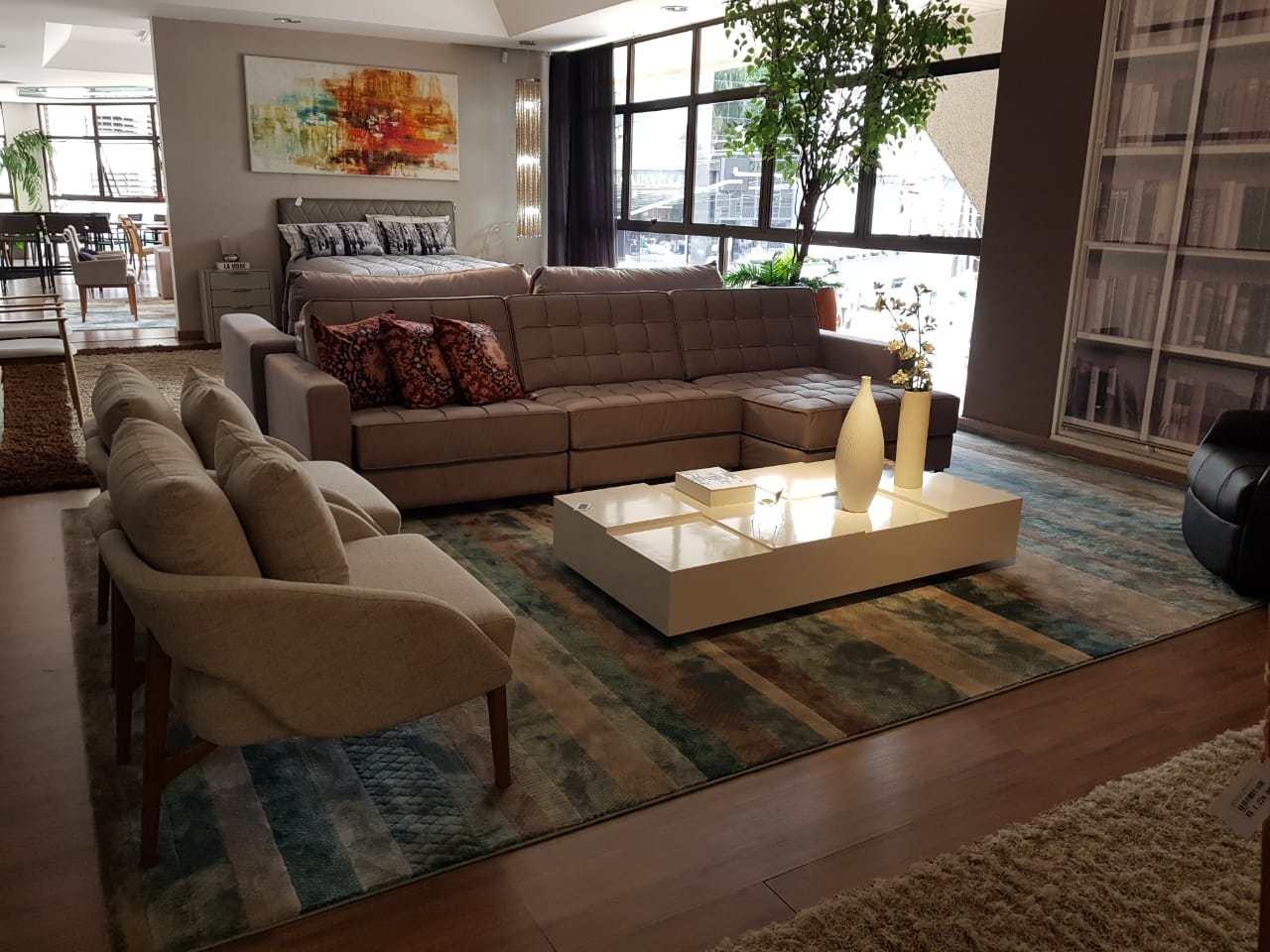 Striped blue rug seen from above, framed by two sofas on a dark wood floor