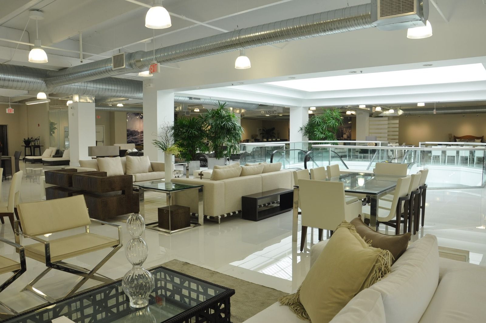 Open furniture floor lit by pendants below exposed ductwork