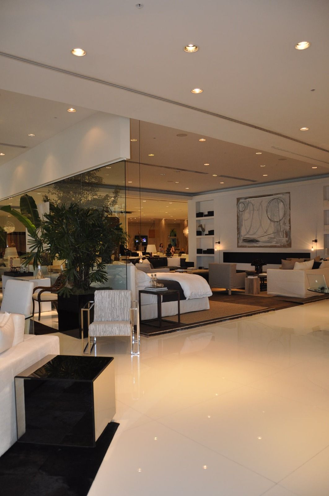 Display floor doubled by a full-height mirrored wall above a black plinth