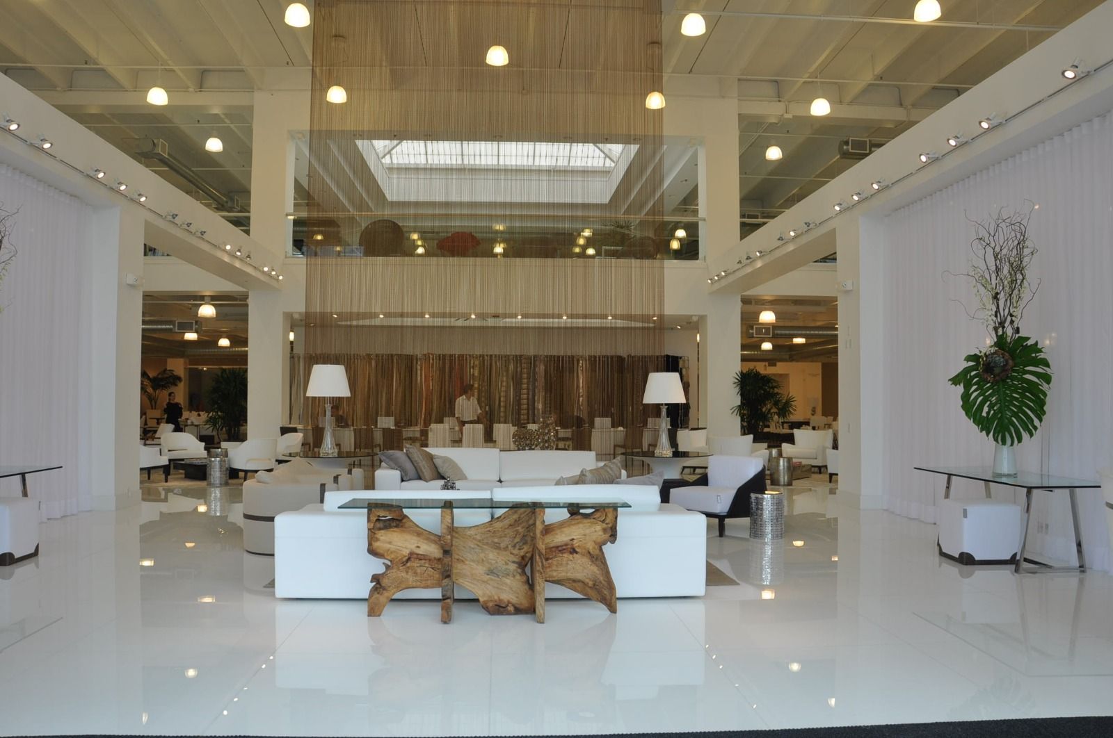Showroom atrium under a skylight, with a mezzanine running around three sides