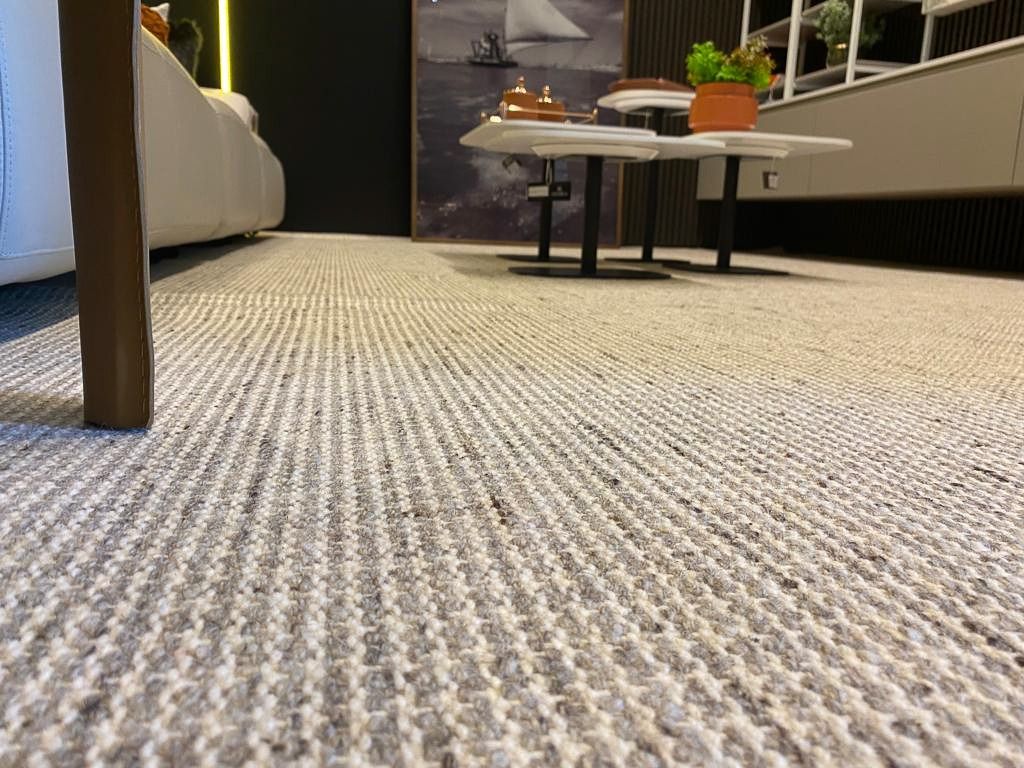 Bouclé rug running across the showroom floor toward a low table