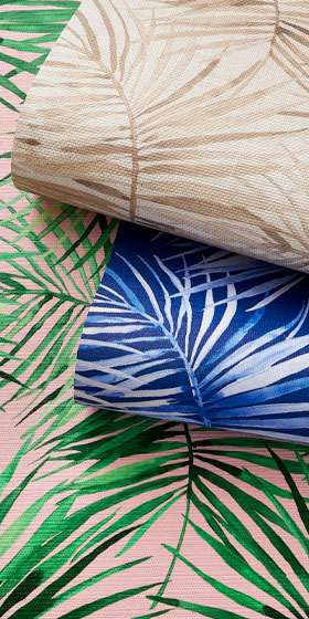 Layered wallpaper rolls printed with crisp green and blue botanical leaf patterns