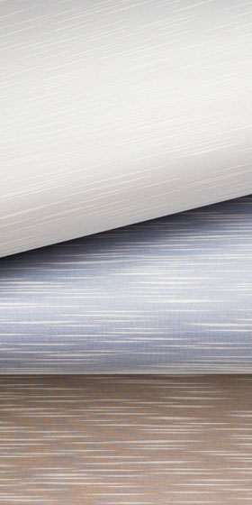 Close-up rolls of pale silk and sateen wallcovering with fine horizontal strié